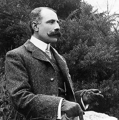 Photograph of Edgar Elgar sat outside dressed formally