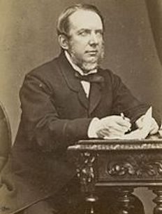 Black and white portrait of Michael Balfe sat at a desk writing